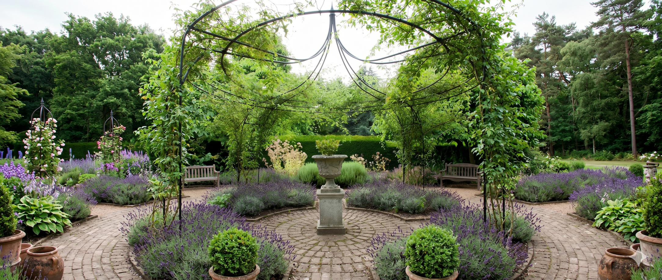 Underside of an Agriframes Gothic Gazebo installed in flowerbeds on a large patio, with a stone planter underneath.
